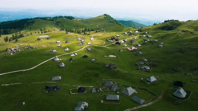 Aerial view Big Pasture Plateau Velika Planina Alpine Village, Slovenia. Nature Landscape in Julian Alps with Old Wooden Houses in Mountains