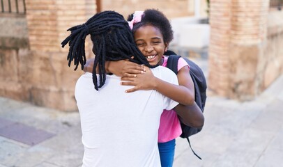 Father and daughter smiling confident hugging each other at school