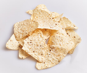 A pile of crispy tortilla chips scattered on a plain white background, perfect for snacking or party menus.