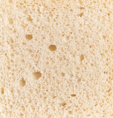 Close-up texture of white bread showing detailed porous structure suitable for food and baking concepts.