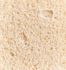 Closeup texture of a porous beige bread slice, symbolizing bakery, food, and nutrition.