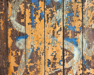 Stara, drewniana ściana, drzwi, z derek, z obłuszczoną pomarańczową farbą i starym graffiti 