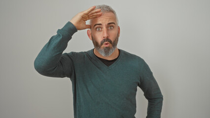 A surprised middle-aged caucasian man with a beard salutes against a white background, conveying a...
