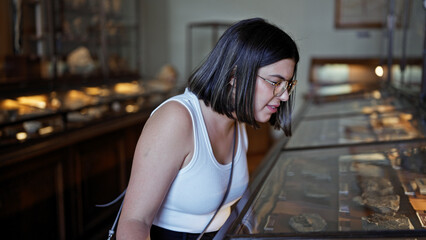 Young beautiful hispanic woman visiting paleontology exhibition at Natural History Museum in Vienna