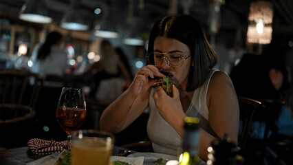 Young beautiful hispanic woman eating delicious italian food at the restaurant