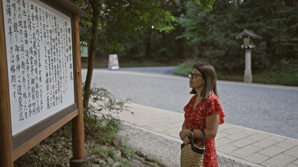 Radiant hispanic woman engrossed in reading meiji temple map and history, captivating beauty...