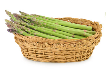 fresh asparagus in in a wicker basket isolated on white background
