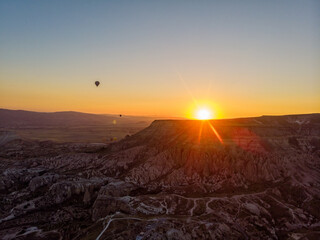 Aerial view of hot air balloons at dawn against the light, flying over the valleys of Cappadocia, 07-08-2019. Turkey