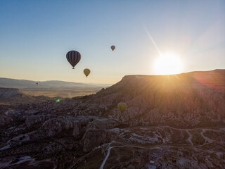 Aerial view of hot air balloons at dawn against the light, flying over the valleys of Cappadocia, 07-08-2019. Turkey