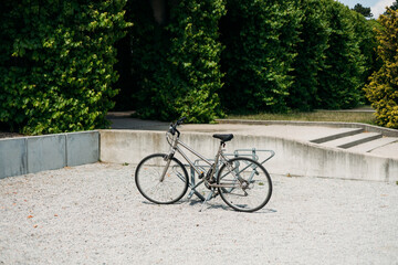 Fototapeta premium Locked bicycle at bicycle parking. Transport, storage and vehicle concept. Green pergola in Park