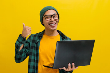 Cheerful Asian man in a beanie and casual clothes gives a thumbs up, expressing satisfaction while...