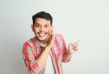 Funny Asian man is whispering some secret gossip isolated on white background.