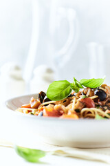 Spaghetti Pasta with Vegetables and fresh Basil on bright wooden Background.