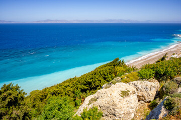 Aegean beach with sunshades in city of Rhodes (Rhodes, Greece)