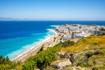 Aegean beach with sunshades in city of Rhodes (Rhodes, Greece)