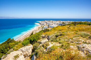 Aegean beach with sunshades in city of Rhodes (Rhodes, Greece)