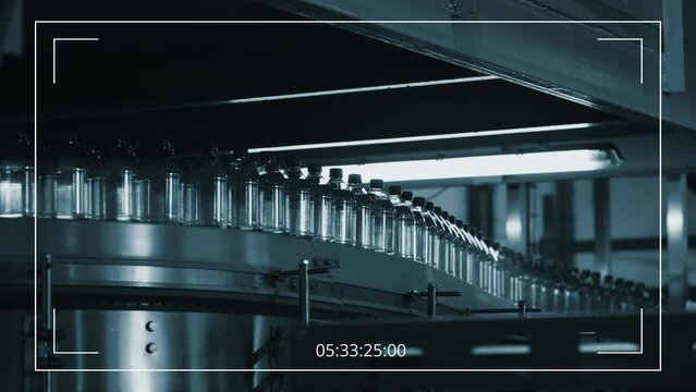 No people surveillance shot of production line at beverage plant, and bottles of filtered water moving on automated conveyor