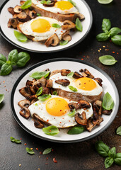 Mushrooms and fried eggs on toast with herbs breakfast