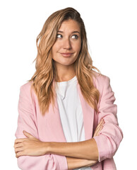 Young blonde in stylish pink suit dreaming of achieving goals and purposes
