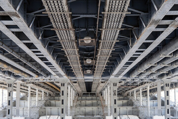 Under-bridge technical infrastructure with a network of pipes and cables