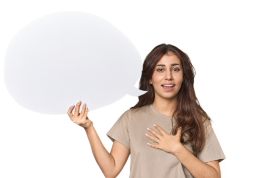 Middle Eastern woman holding comic bubble laughs out loudly keeping hand on chest.