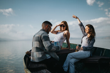 Three friends share a joyful moment on a boat, surrounded by calm waters, exuding happiness and...