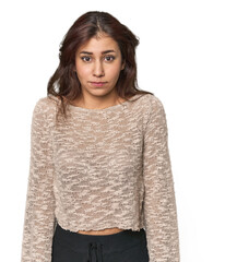 Middle Eastern woman in studio shrugs shoulders and open eyes confused.