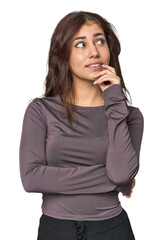 Middle Eastern woman in studio relaxed thinking about something looking at a copy space.