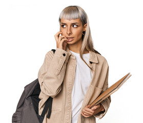 Caucasian young student with books biting fingernails, nervous and very anxious.