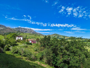 Fototapeta premium Houses at Sardera village and Sierra del Sueve in background, Asturias, Spain