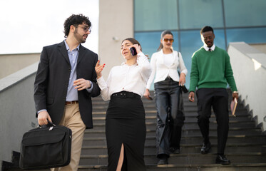 A dynamic image of business professionals in smart attire descending outdoor stairs, engaged in...