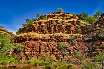 Magnificent reddish brown banded ironstone formation, looking like a prehistoric castle, in the Dales Gorge, Karijini National park, Hamersley Range, Western Australia
