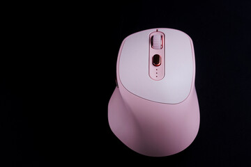 Unusual pink computer mouse with additional buttons on a black background. Photo. Copy space