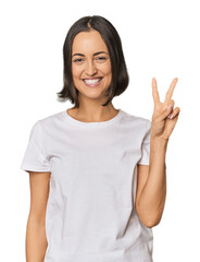 Young Caucasian woman with short hair joyful and carefree showing a peace symbol with fingers.