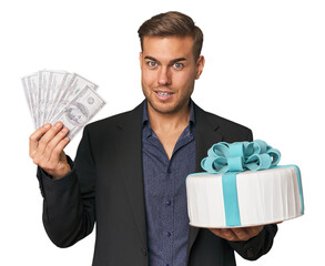Young man with dollars and cake, merging finance with celebration