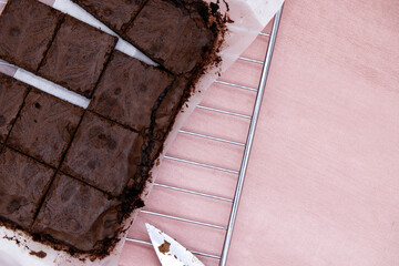 Brownies with pink background. Concept of baking brownies with dark chocolate. Home cooking with...