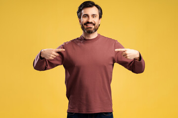 Smiling man in casual pointing fingers to himself, looking at camera, isolated