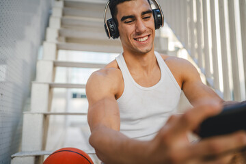 Portrait of man use headphones and smart phone to play video games