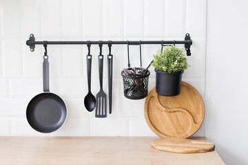 Hanging black kitchen utensils white wall