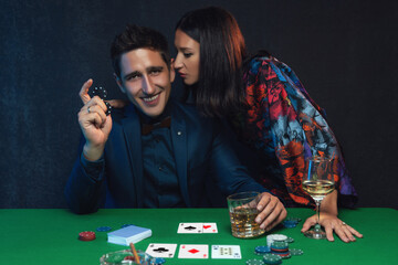 Couple playing poker at the green table in casino.