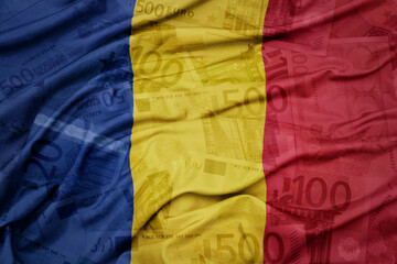 waving colorful national flag of romania on a euro money banknotes background. finance concept.
