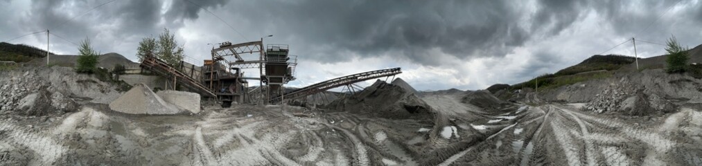 Carpathian Mountains of Ukraine, a quarry where granite sandstone is mined for the production of building materials, powerful trucks and conveyors load gravel - video from a drone