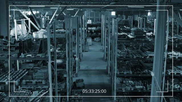 Suveillance camera high-angle no people footage of multiple rows of racks with spare metal repair parts at warehouse of heavy machinery production plant
