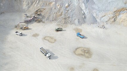 Heavy Machines and Loading Trucks in Stone Quarry. Transporting Gravel and Sand. Aerial