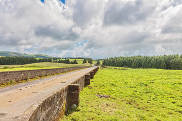 road through green valley landscape on Sao Miguel island, Portugal