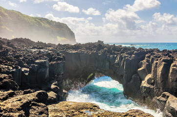 Atlantic ocean wave breaks on the big rocky stone on the beautiful beach of Sao Miguel island
