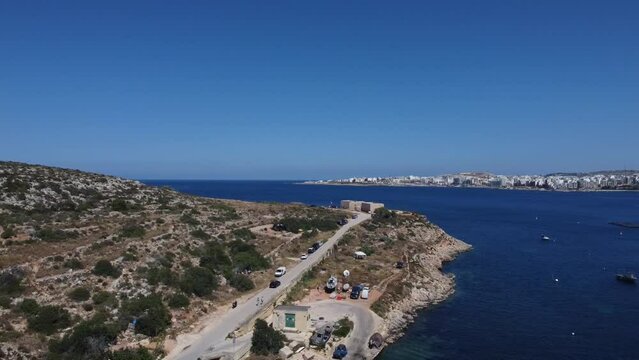 Aerial view of Mistra battery from Mistra bay. Qawra aquarioum and Bugibba promenade in the distance. . High quality FullHD footage
