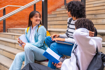 Multi-ethnic students sitting in stairs chatting in the university