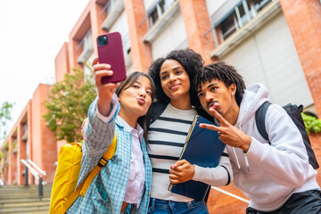 Happy multiracial university students taking a selfie outside the campus