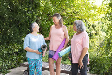Diverse senior women, chatting outdoors, wearing casual sportswear